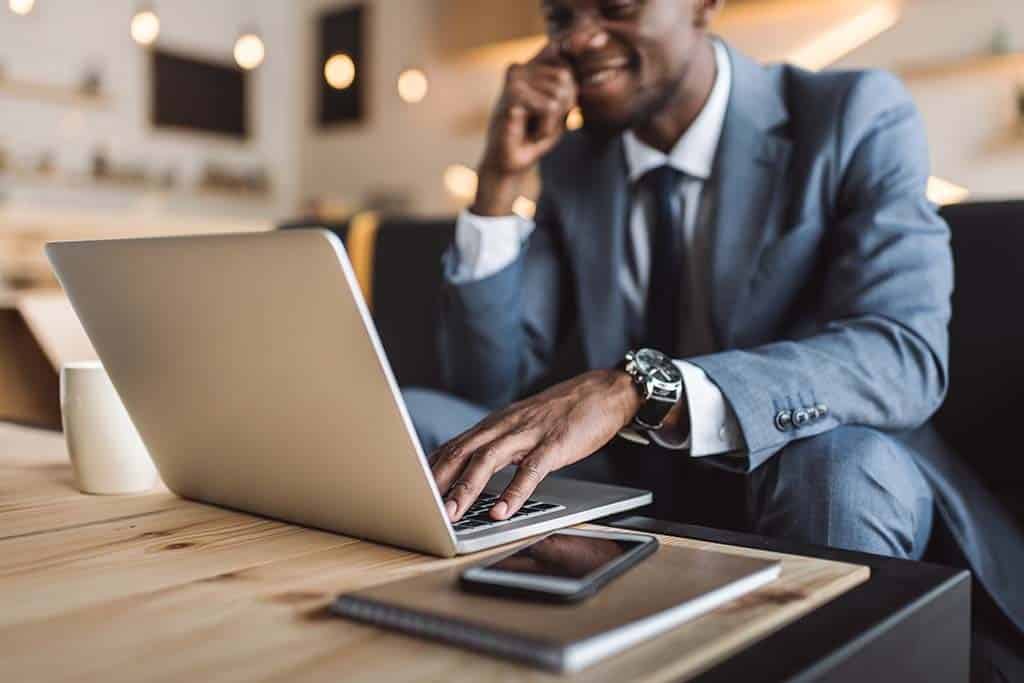 Businessman in suit works at laptop computer