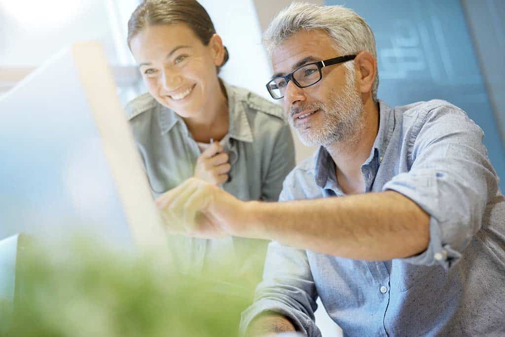two people gesture at a computer representing IT services