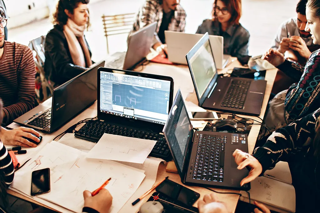 Group of office employees working on computers, illustrating when to replace aging office computers